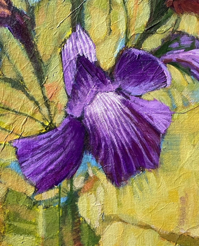 A little purple purple flower standing in the grass enjoying the breeze