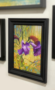 A little purple purple flower standing in the grass enjoying the breeze