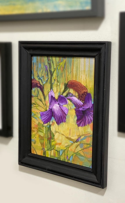 A little purple purple flower standing in the grass enjoying the breeze